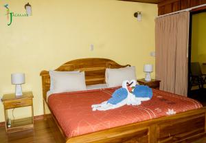 a bedroom with a bed with a stuffed bird on it at Jacamar Corcovado Drake Bay in Drake