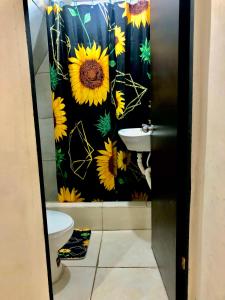 baño con cortina de ducha de girasol y lavamanos en Hospedaje Maluli suit 4, en Santa Elena