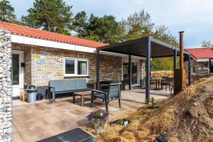 a patio with two benches and a pavilion at Nesserduinen in Nes