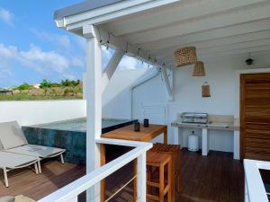 Dieses weiße Haus bietet eine Terrasse mit Meerblick. in der Unterkunft SUNSEEKER SXM - Jardins Orient Bay - Appartement vue mer ou Studio vue Colline in Saint Martin