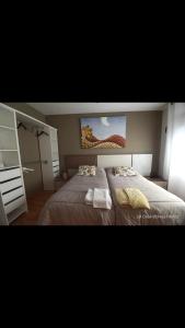Rabanales的住宿－La Casa de mis Padres，一间卧室设有两张床,墙上挂着一幅画