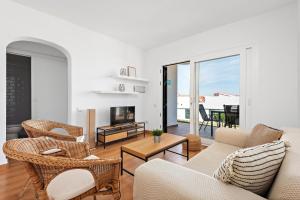 a living room with a couch and chairs at Apartamento Can Harmonia - Arenal den Castell in Arenal d'en Castell