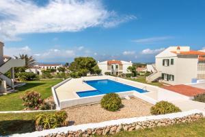 a villa with a swimming pool in a yard at Apartamento Can Harmonia - Arenal den Castell in Arenal d'en Castell
