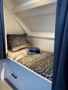 a small bed in a small room with a bed sqor at Landelijk gelegen vakantiehuis met hottub! 
