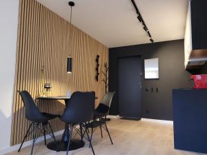 a dining room with black chairs and a table at Apartament z sauną Polanica-Zdrój in Polanica-Zdrój