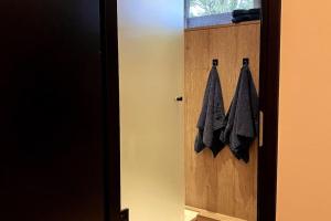 a bathroom door with black towels hanging on it at Landelijk gelegen vakantiehuis met hottub! in Tollebeek +24 photos