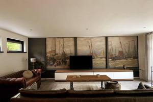 a living room with a large painting of ships on the wall at Landelijk gelegen vakantiehuis met hottub! 