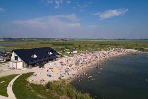 a large crowd of people on a beach near the water at Landelijk gelegen vakantiehuis met hottub! 