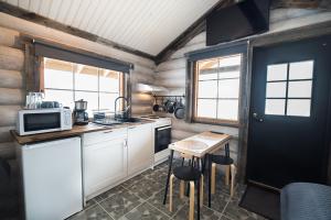 a small kitchen with a table and a microwave at Naali Mökki in Kilpisjärvi