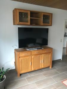 a large entertainment center with a large flat screen tv at Ferienhaus am Heringskoop in Nordleda