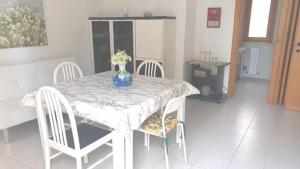 una mesa con sillas y un jarrón de flores. en R07 Trilocale con terrazzo e garage, en Numana