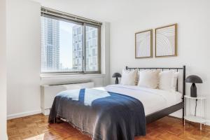 Un dormitorio blanco con una cama grande y una ventana. en LIC 2BR w WD Elevator Doorman nr E River NYC-766, en Nueva York 34 fotos más