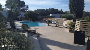 a backyard with a swimming pool and a fence at Mimosas - villa in Fréjus