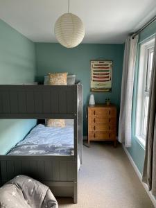 1 dormitorio con litera y paredes azules en Three bedroom holiday house Porthleven, Cornwall. Close to shops and beach, en Porthleven