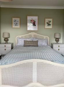 1 cama blanca grande en un dormitorio con 2 lámparas en Three bedroom holiday house Porthleven, Cornwall. Close to shops and beach, en Porthleven