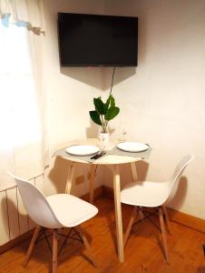查克拉斯德科里亞的住宿－Aires de Coria，一张桌子、两把椅子和墙上的电视