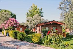 a small house in a garden with flowers at Kervan Tatil Köyü in Edremit