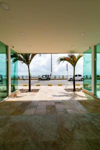 a lobby with palm trees and a view of the ocean at Yak Beach Hotel Natal in Natal