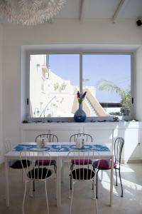 un comedor blanco con mesa y sillas en B&B La Palma en Santa Marina Salina