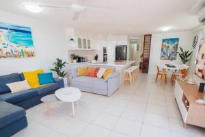 a living room with a couch and a table at Waterfront Apt Maroochy River in Maroochydore