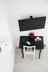 escritorio negro con silla blanca y TV en B&B La Palma, en Santa Marina Salina