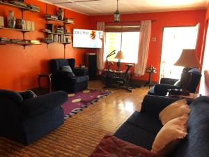 a living room with two couches and a television at Nat’s place in Treasure Beach