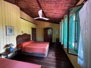a bedroom with a bed and a ceiling fan at Hotel Veragua River House in Sierpe