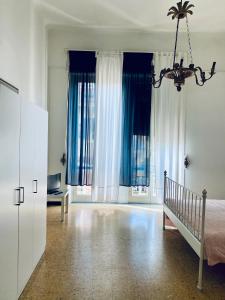 ラ・スペツィアにあるMY HOUSE to Cinque terreのベッドルーム1室(青いカーテン、ベッド1台、シャンデリア付)