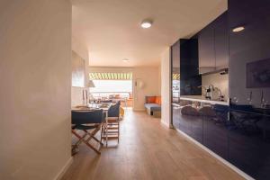 a kitchen and living room with a table and chairs at Ático 1ª línea de playa en Puerto de Aguadulce in Almería