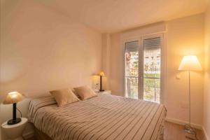 um quarto branco com uma cama e uma janela em Ático 1ª línea de playa en Puerto de Aguadulce em Almeria