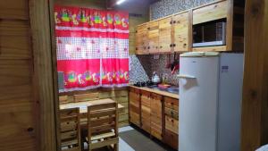 cocina con cortina roja y nevera en Sobrado Rustico iguacu en Foz do Iguaçu