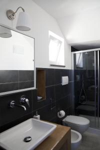 a bathroom with a white sink and a toilet at B&B La Palma in Santa Marina Salina