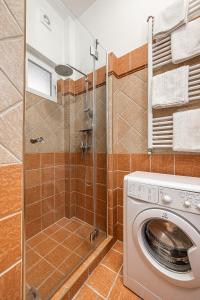 een wasmachine in een badkamer met een douche bij Budapest Then & Now Apartment in Boedapest