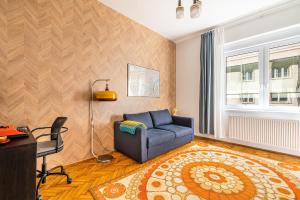 een woonkamer met een blauwe bank en een raam bij Budapest Then & Now Apartment in Boedapest