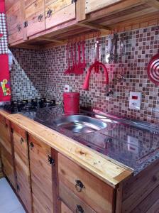 um balcão de cozinha com um lavatório na cozinha em Sobrado Rustico iguacu em Foz do Iguaçu