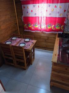 Habitación con mesa, sillas y cortina roja en Sobrado Rustico iguacu, en Foz do Iguaçu