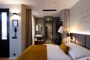 a bedroom with a large bed and a bathroom at Hotel Prokop Square in Prague