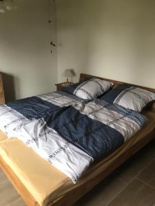 a large bed with a blue blanket on it at Ferienhaus am Heringskoop in Nordleda