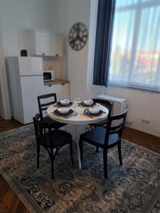 una mesa de comedor con 4 sillas en una habitación en Weisz Apartment - Free Private Parking,Wifi,Hot Drinks en Carei