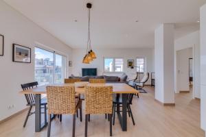 een eetkamer en een woonkamer met een tafel en stoelen bij FormosaFuzeta Seaview @Homesbyfc in Fuzeta