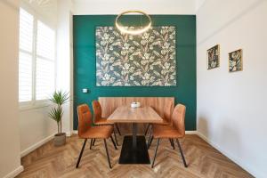 una sala da pranzo con tavolo e sedie in legno di Nove Boutique Apartments a Vienna