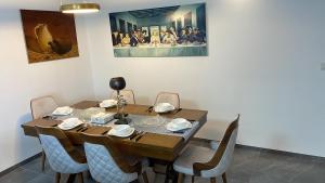 a dining room table with chairs and a painting on the wall at חופשה בטבריה בבית ענק ל 8 אנשים גדול וחדש in Tiberias