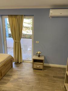 a bedroom with a bed and a sliding glass door at Persephone in Himare
