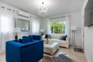 un soggiorno con mobili blu e lampadario a braccio di La Vida Delray 1 a Delray Beach