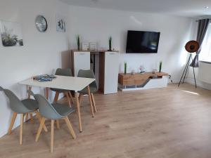 a dining room with a table and chairs and a television at Kutscherhaus in Nagel