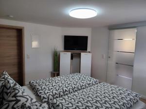 a bedroom with a bed and a flat screen tv at Kutscherhaus in Nagel