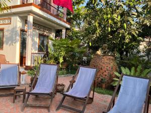 three chairs sitting in front of a house at Happy Family Guesthouse in Vĩnh Long