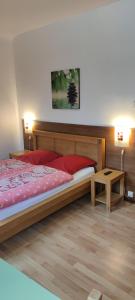 a bedroom with a bed with red pillows and a table at Chambre d'hôtes de la tulipe in Mittelbergheim