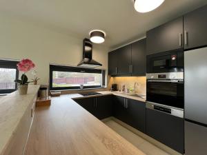 a kitchen with black cabinets and a large window at Luxury Villa Rosemary with free garage in Szentendre in Szentendre