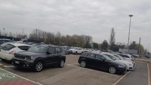 een parkeerplaats met veel auto's geparkeerd in bij Residence Ki House in Parma